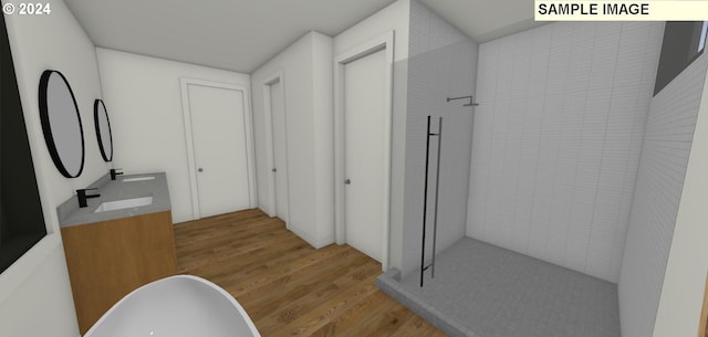 bathroom featuring hardwood / wood-style flooring, vanity, and a tile shower