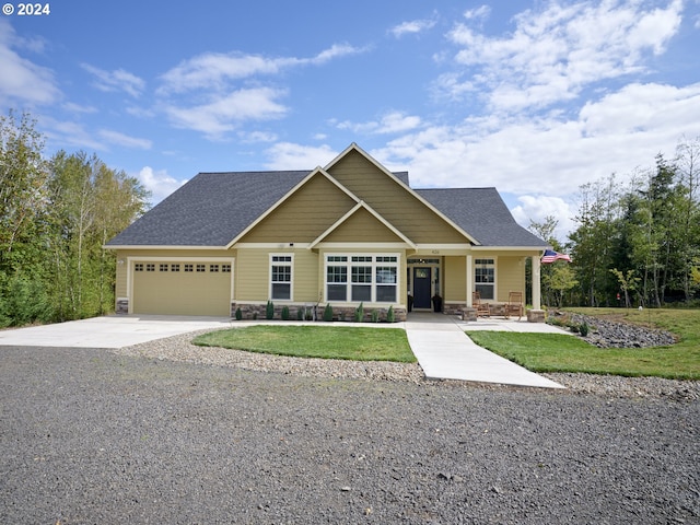 craftsman inspired home with a garage and a front lawn