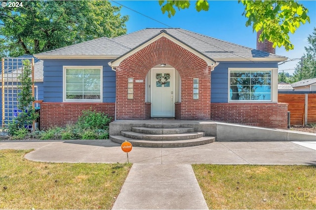 bungalow-style home featuring a front yard