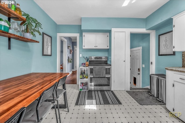 kitchen with double oven range and white cabinets