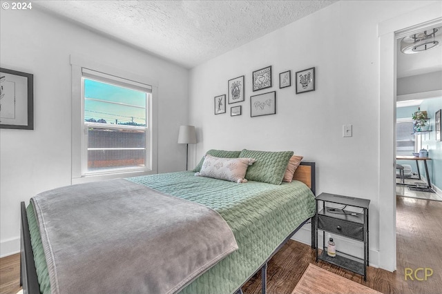 bedroom featuring dark wood-type flooring and a textured ceiling