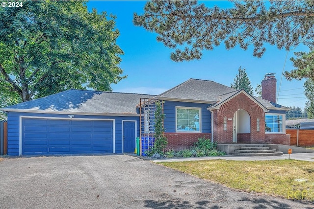 single story home featuring a garage and a front lawn