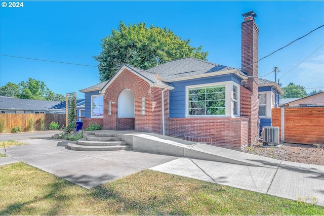 view of front of property featuring central AC and a front lawn