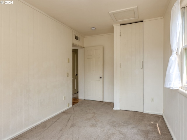 unfurnished bedroom featuring light colored carpet and ornamental molding