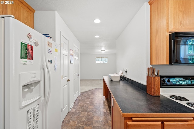 kitchen featuring dark carpet and white appliances