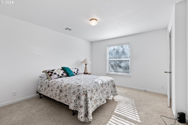 carpeted bedroom featuring a textured ceiling