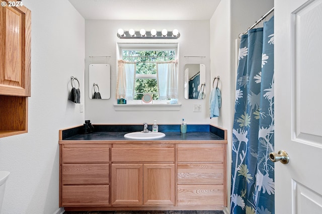 bathroom with vanity, a textured ceiling, and toilet