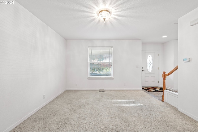 carpeted entrance foyer with a healthy amount of sunlight