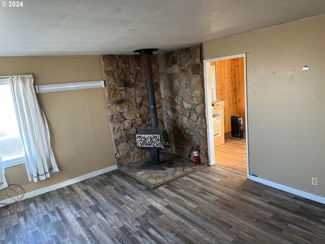 unfurnished living room with dark hardwood / wood-style flooring and a wood stove