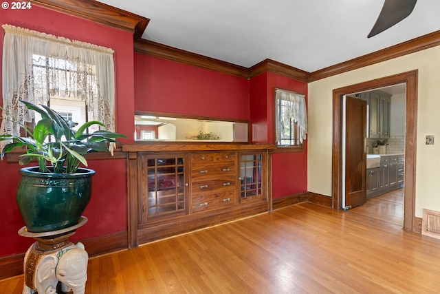 bar featuring hardwood / wood-style floors, backsplash, and crown molding