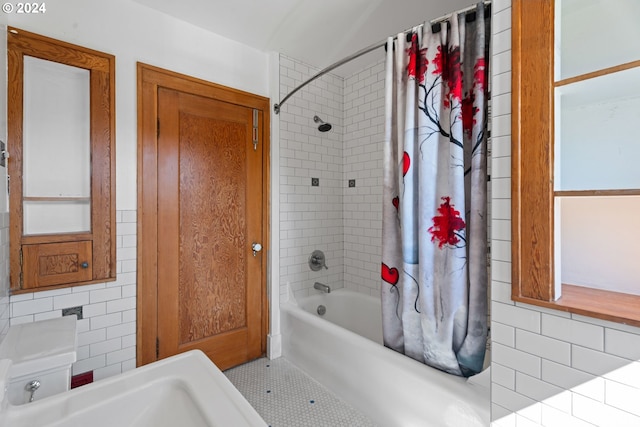 bathroom featuring tile patterned flooring, toilet, tile walls, and shower / tub combo