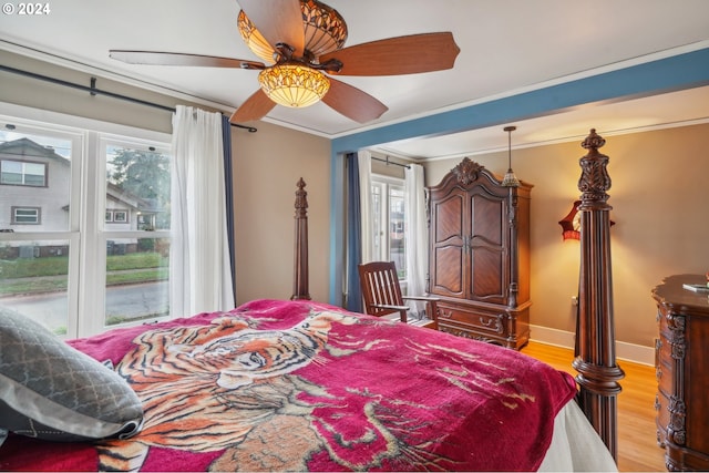 bedroom with ceiling fan, ornamental molding, and light wood-type flooring