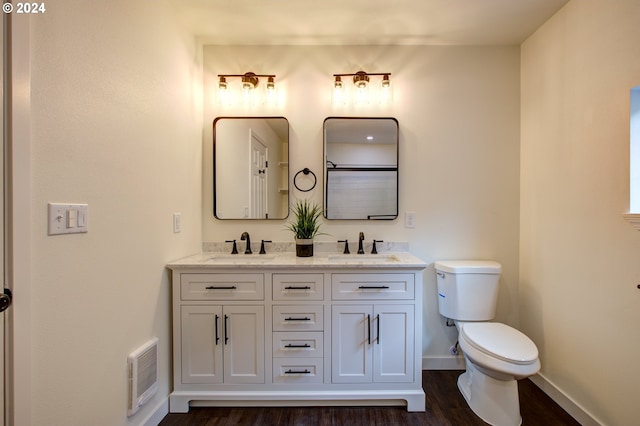 bathroom featuring toilet, vanity, and hardwood / wood-style floors