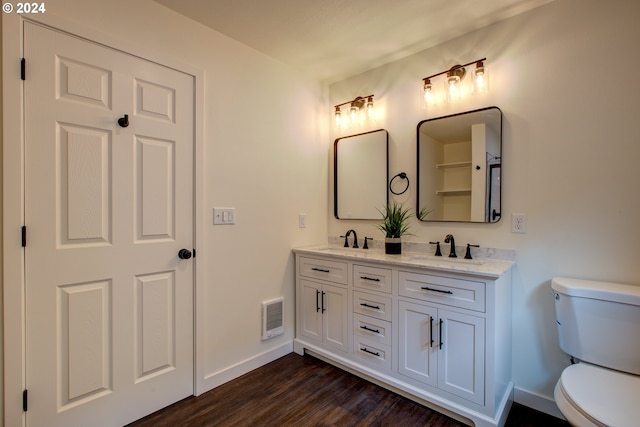 bathroom featuring toilet, vanity, and wood-type flooring