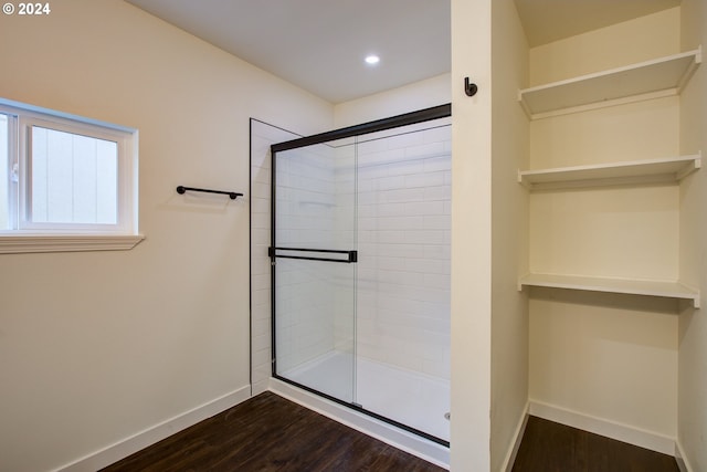 bathroom with wood-type flooring and a shower with shower door