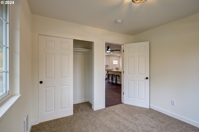 unfurnished bedroom featuring multiple windows, a closet, and carpet floors