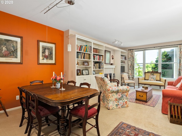 carpeted dining room with rail lighting