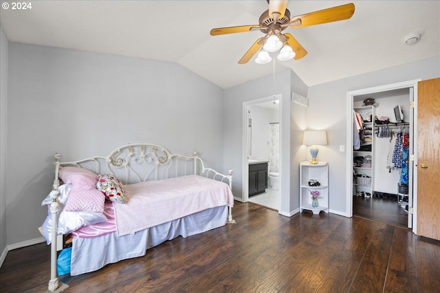 bedroom featuring vaulted ceiling, a walk in closet, ensuite bathroom, dark wood-type flooring, and ceiling fan