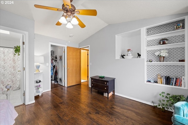 bedroom featuring vaulted ceiling, a spacious closet, dark hardwood / wood-style flooring, ensuite bath, and ceiling fan