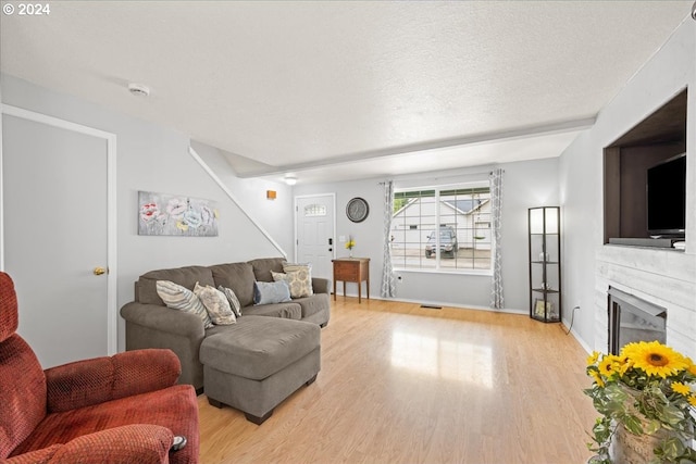 living room with a textured ceiling and light hardwood / wood-style flooring