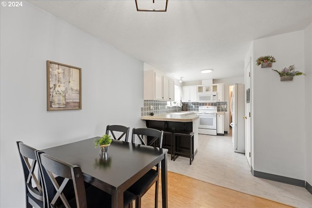 dining area with light hardwood / wood-style floors and sink