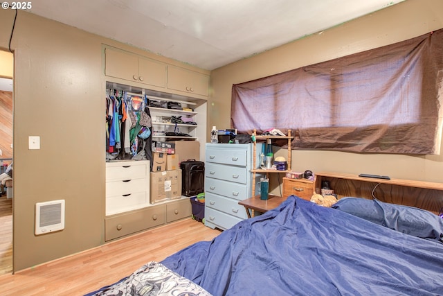 bedroom with light hardwood / wood-style floors and a closet