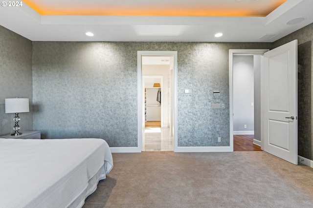 bedroom featuring a tray ceiling and carpet floors