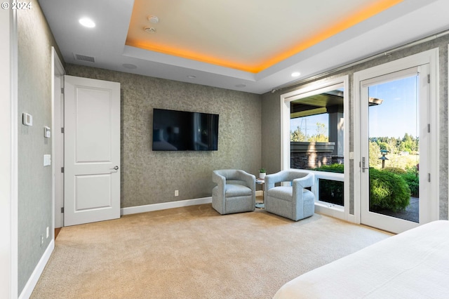 bedroom featuring access to outside, light carpet, and a raised ceiling