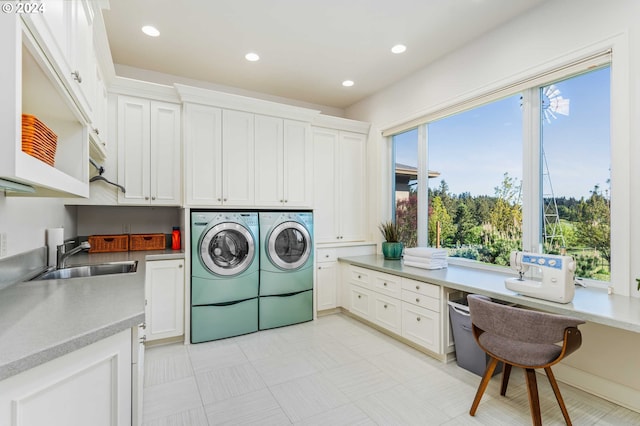 clothes washing area with a healthy amount of sunlight, sink, light tile floors, and cabinets