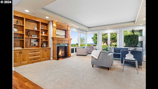 living room featuring a tray ceiling and light hardwood / wood-style flooring