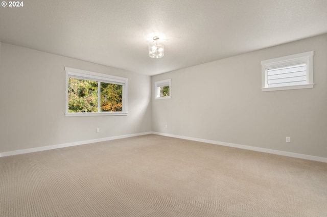 carpeted spare room with a notable chandelier