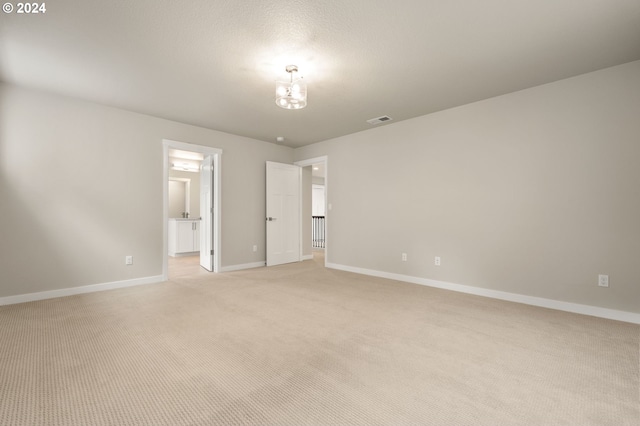 unfurnished bedroom with light carpet and ensuite bath