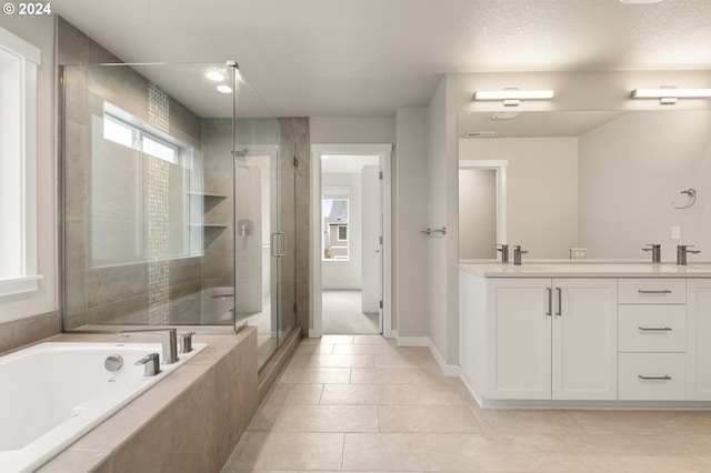 bathroom with tile patterned floors, vanity, independent shower and bath, and a textured ceiling