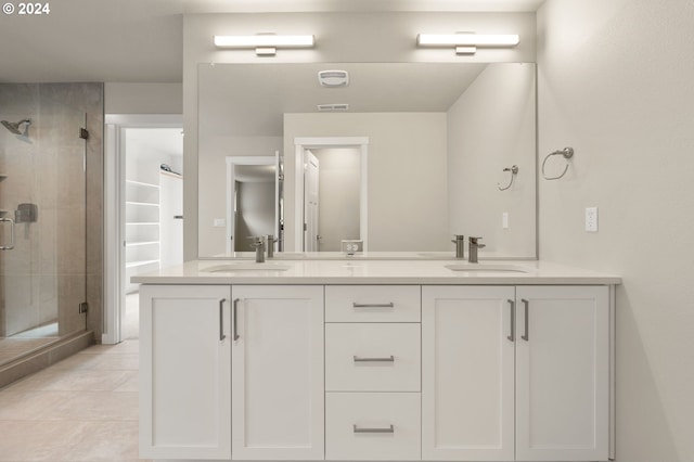 bathroom with tile patterned floors, vanity, and a shower with door