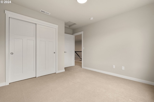 unfurnished bedroom featuring light carpet and a closet