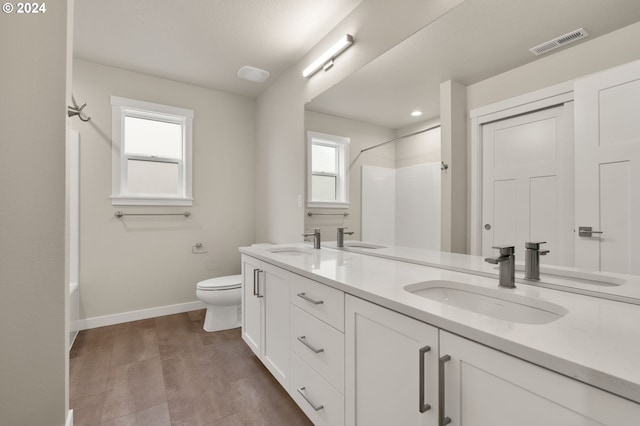 bathroom with a wealth of natural light, hardwood / wood-style floors, vanity, and toilet