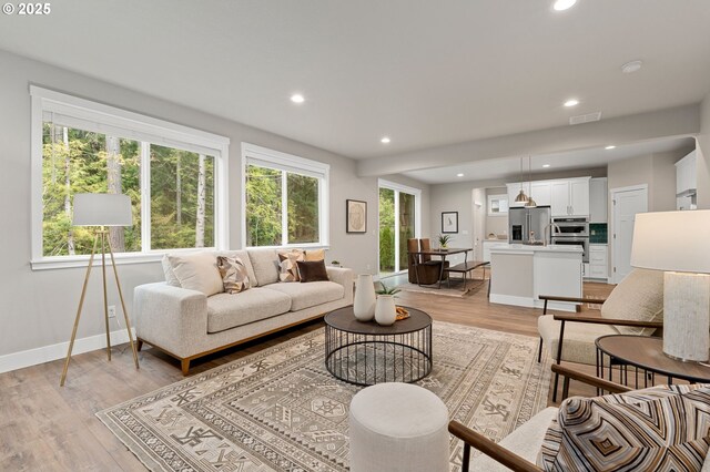 unfurnished living room with sink and light hardwood / wood-style flooring