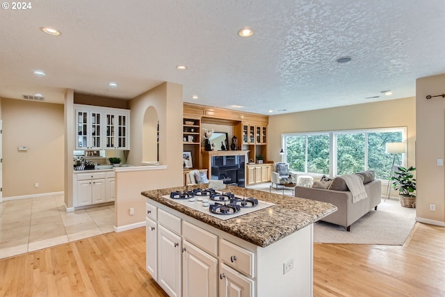 kitchen with white cabinets, light wood-type flooring, and a kitchen island