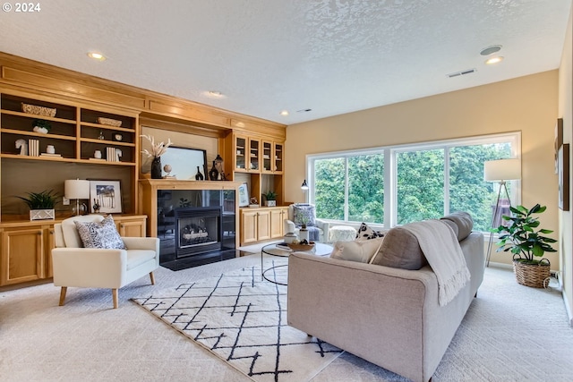 carpeted living room featuring a textured ceiling and a tile fireplace