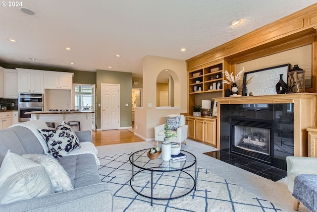 living room with a fireplace, built in features, and hardwood / wood-style floors