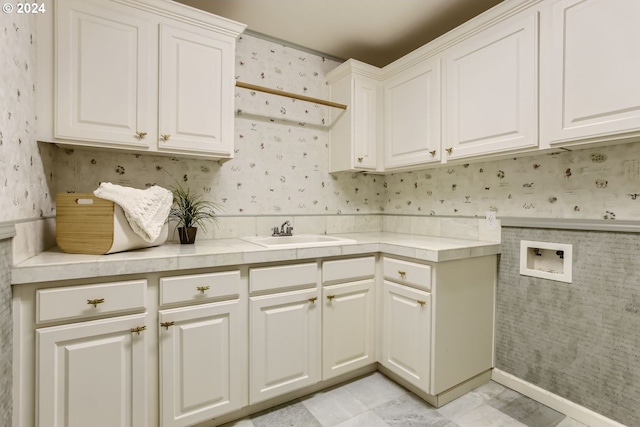 clothes washing area featuring washer hookup, cabinets, and sink