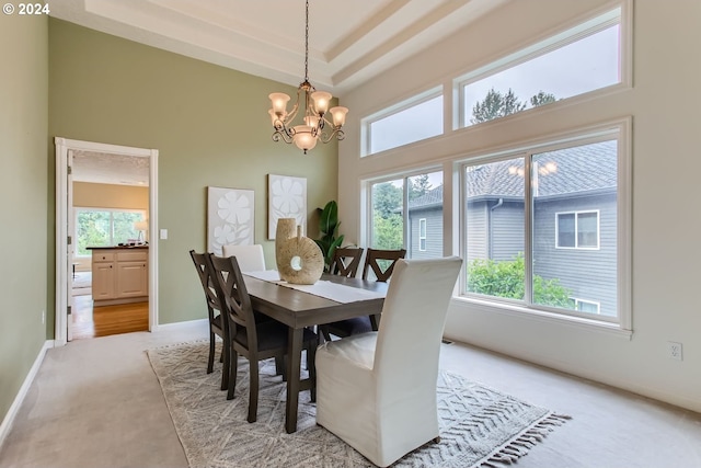 carpeted dining space with a notable chandelier and a towering ceiling