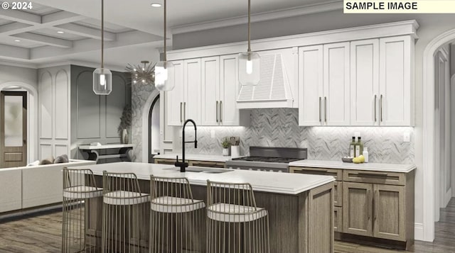 kitchen featuring pendant lighting, dark hardwood / wood-style flooring, white cabinets, a center island with sink, and coffered ceiling