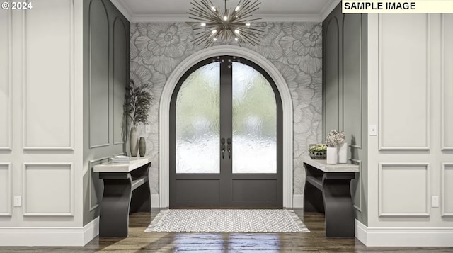 entryway featuring dark hardwood / wood-style floors, an inviting chandelier, ornamental molding, and french doors