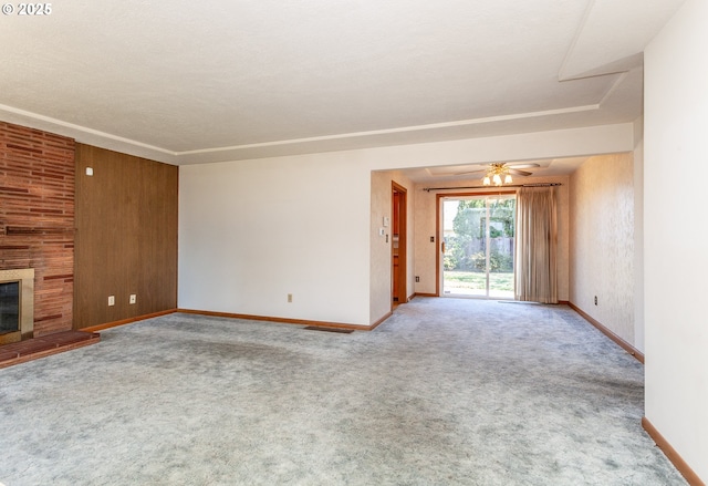 unfurnished living room with a ceiling fan, carpet flooring, a fireplace, and baseboards