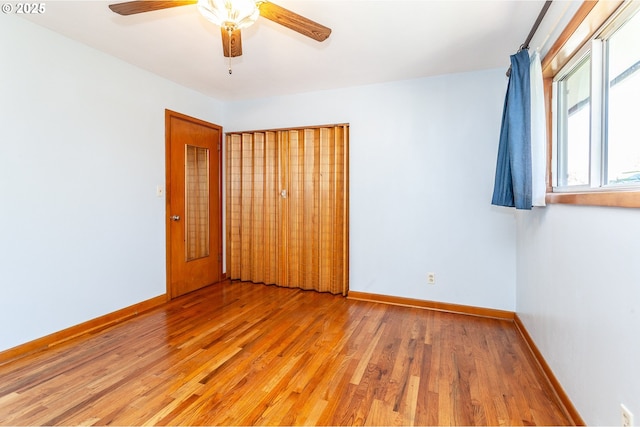 spare room featuring light wood-style floors, ceiling fan, and baseboards