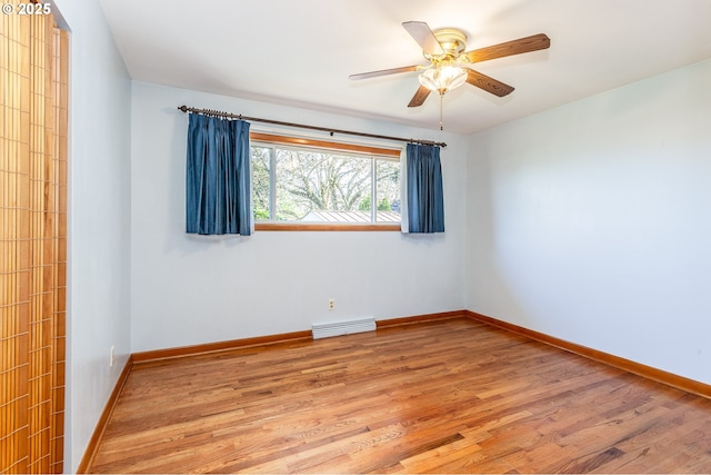 unfurnished room with ceiling fan, light wood finished floors, visible vents, and baseboards