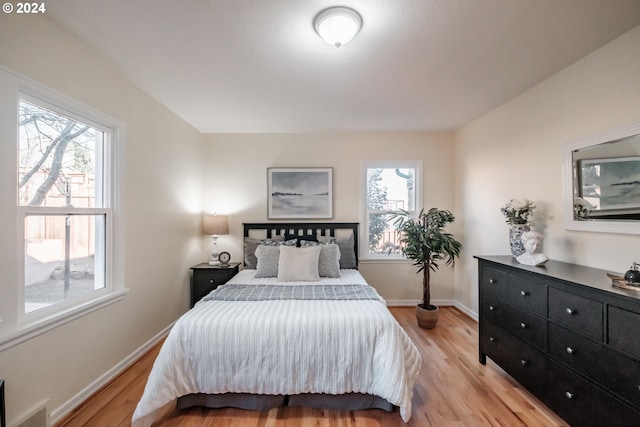 bedroom featuring multiple windows and light hardwood / wood-style floors