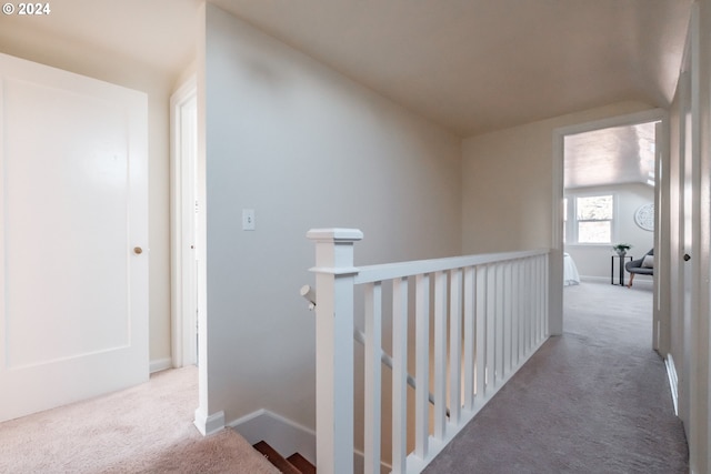 hall featuring light carpet and vaulted ceiling