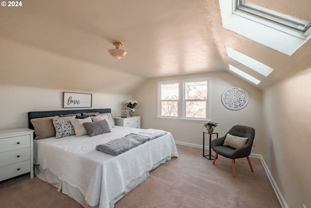 bedroom with light colored carpet and lofted ceiling with skylight